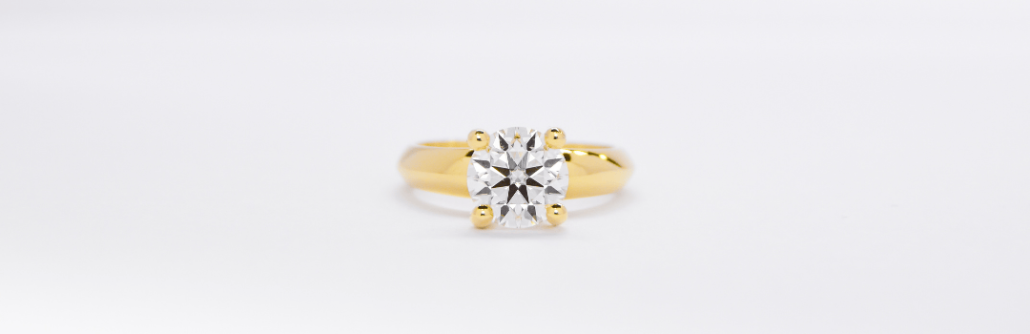 Alianzas de oro 18K amarillo con un diamante Haikmaro Anillo de compromiso de oro 18k amarillo con diamante sobre fondo blanco
